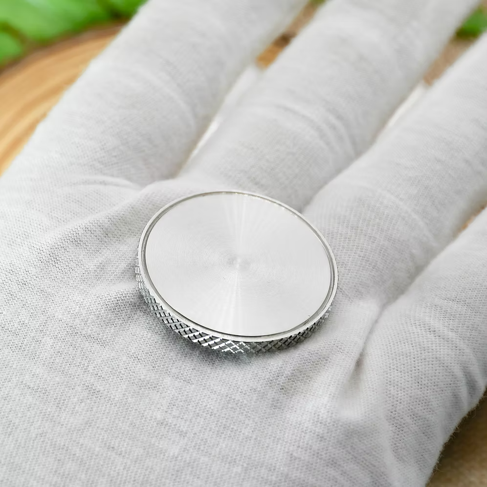 Custom Stainless Steel Ball Marker resting on a hand, showcasing its knurled edge and premium finish.