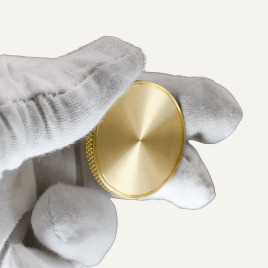 Hand holding a Custom Brass Ball Marker showcasing its knurled edge and premium finish.